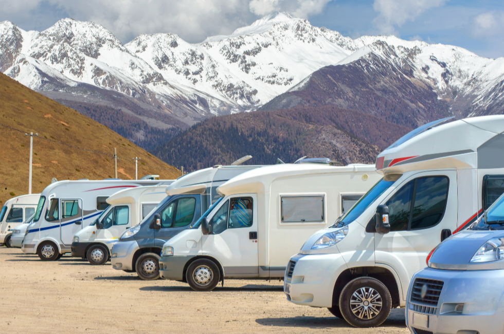 RVs at a park with snowy mountains in the background.