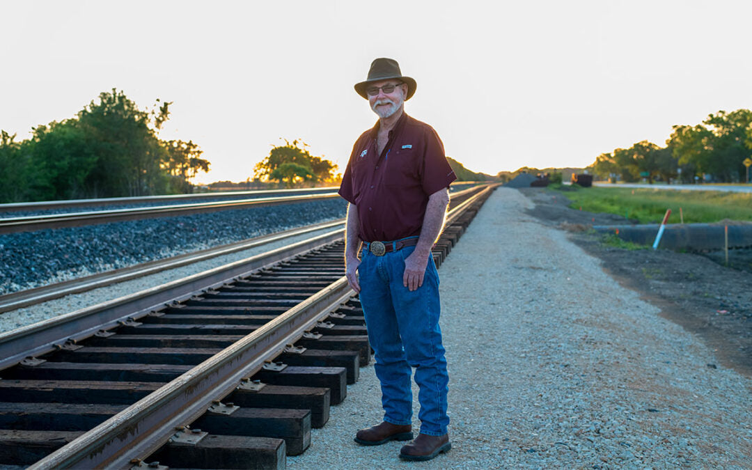 David Baker posing next to train tracks
